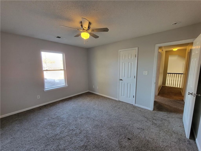 unfurnished bedroom with carpet, a textured ceiling, and ceiling fan