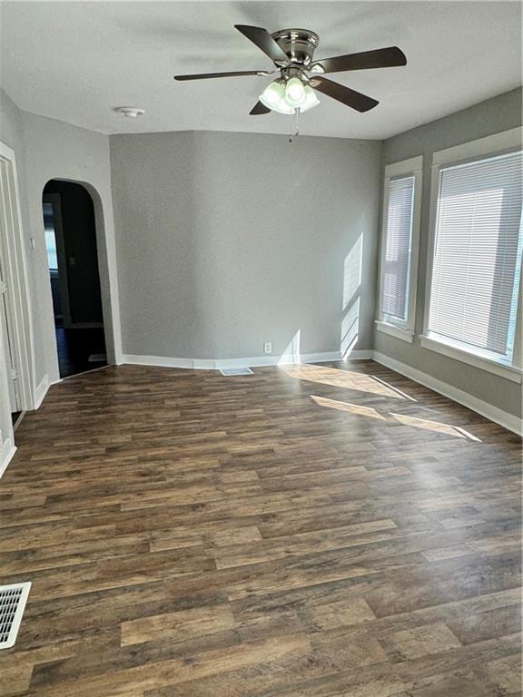 empty room with ceiling fan and dark hardwood / wood-style floors