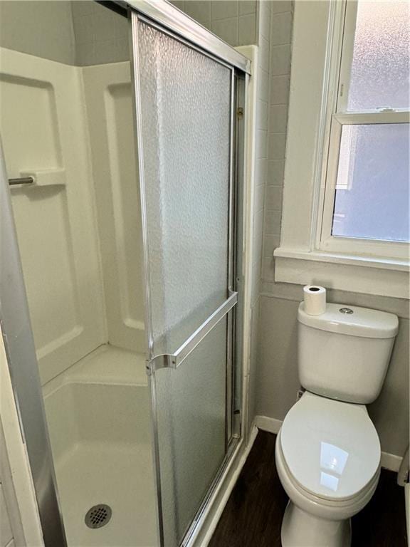 bathroom featuring toilet and an enclosed shower