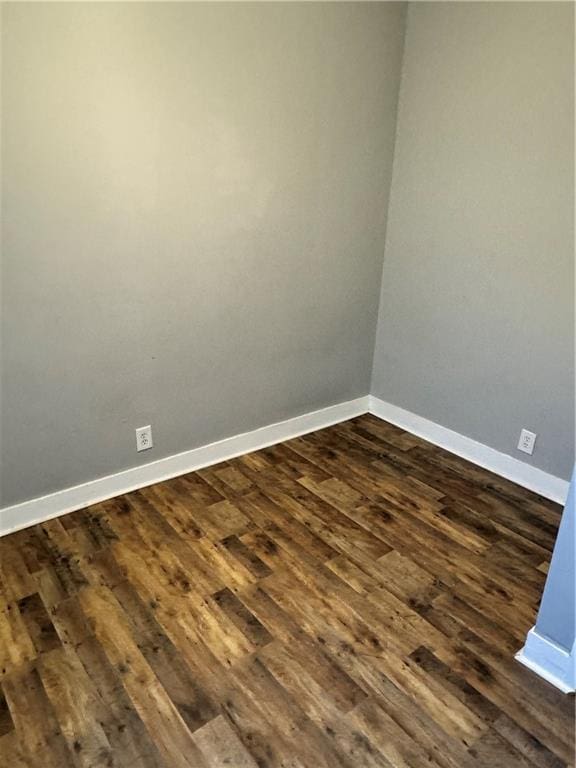 unfurnished room with dark hardwood / wood-style flooring