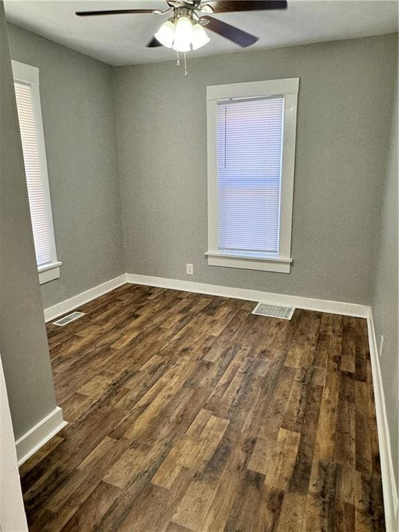 unfurnished room featuring dark wood-type flooring and ceiling fan