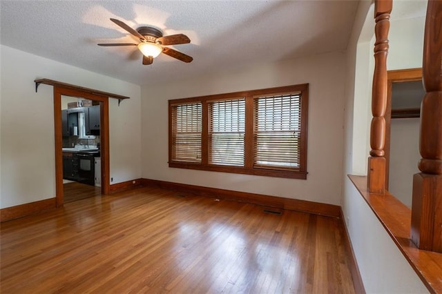 interior space with a textured ceiling, wood-type flooring, and ceiling fan