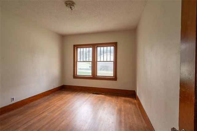 unfurnished room featuring a textured ceiling and hardwood / wood-style floors