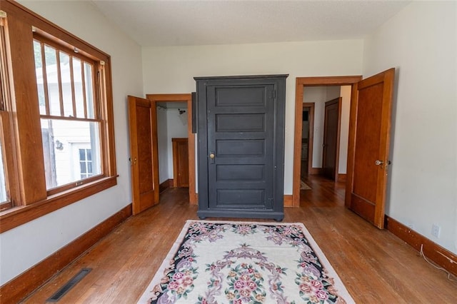 bedroom with multiple windows and hardwood / wood-style floors