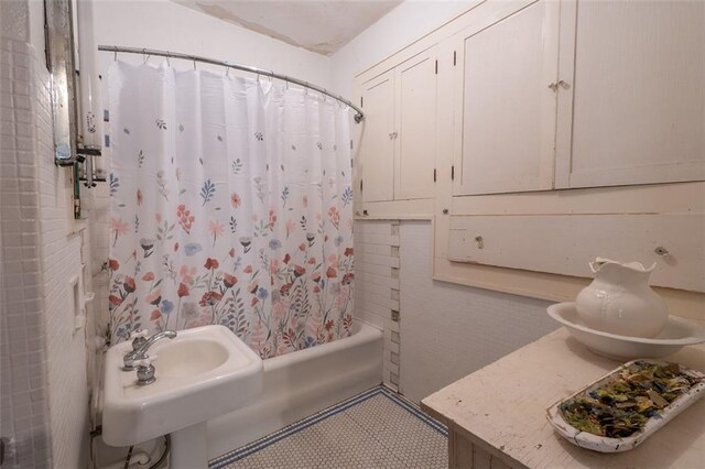 bathroom featuring shower / bath combination with curtain and sink