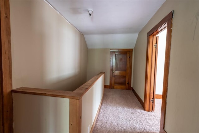 corridor featuring carpet floors and vaulted ceiling