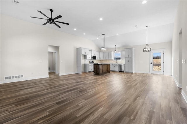 unfurnished living room featuring dark wood-type flooring, lofted ceiling, ceiling fan with notable chandelier, and sink