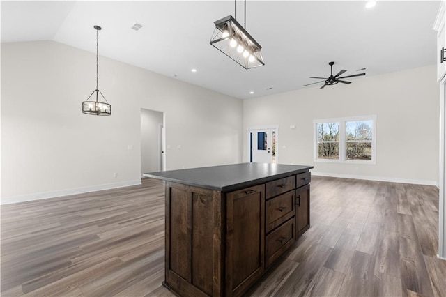 kitchen with a kitchen island, light hardwood / wood-style flooring, hanging light fixtures, dark brown cabinets, and ceiling fan with notable chandelier