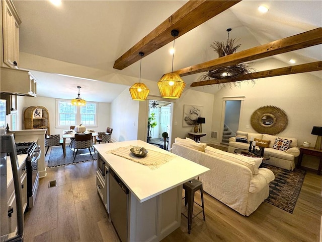 kitchen featuring a center island, appliances with stainless steel finishes, dark hardwood / wood-style flooring, pendant lighting, and beam ceiling