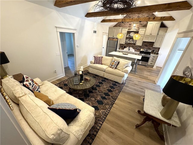 living room featuring lofted ceiling with beams and light wood-type flooring