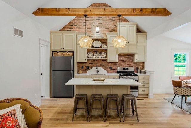 kitchen featuring a kitchen bar, stainless steel appliances, lofted ceiling with beams, a kitchen island, and decorative light fixtures