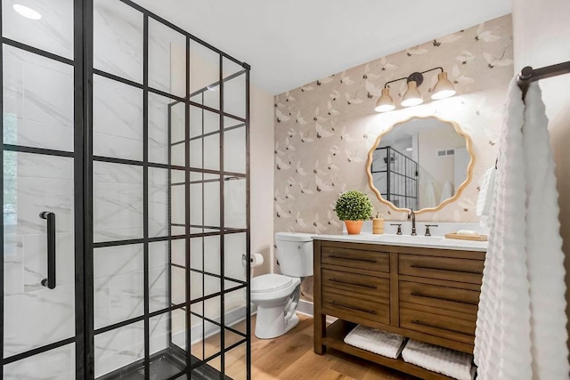 bathroom featuring vanity, hardwood / wood-style floors, walk in shower, and toilet