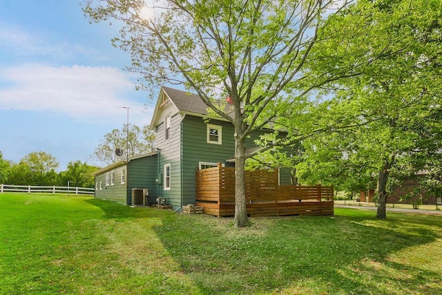 view of side of home featuring central AC unit and a lawn