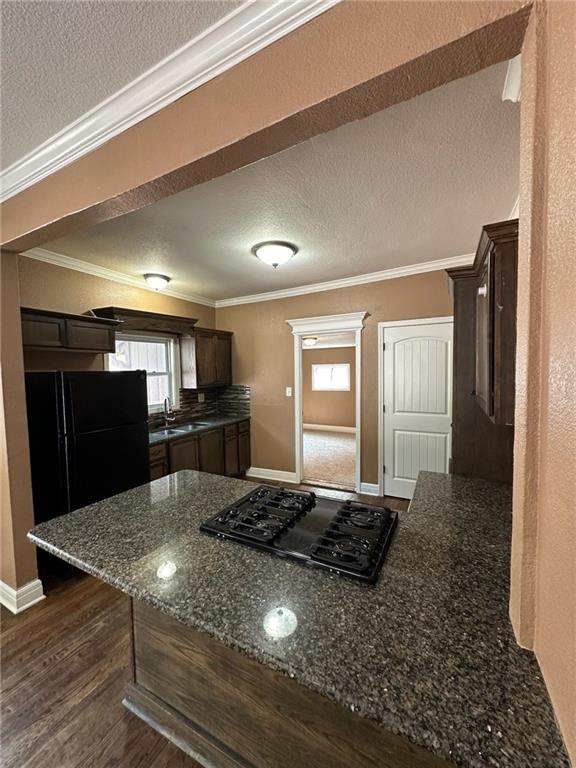 kitchen featuring black appliances, dark hardwood / wood-style flooring, kitchen peninsula, and a textured ceiling