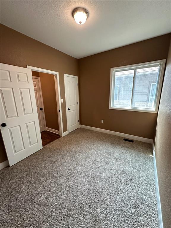 unfurnished bedroom featuring carpet and a textured ceiling