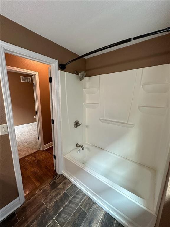 bathroom with hardwood / wood-style flooring and  shower combination