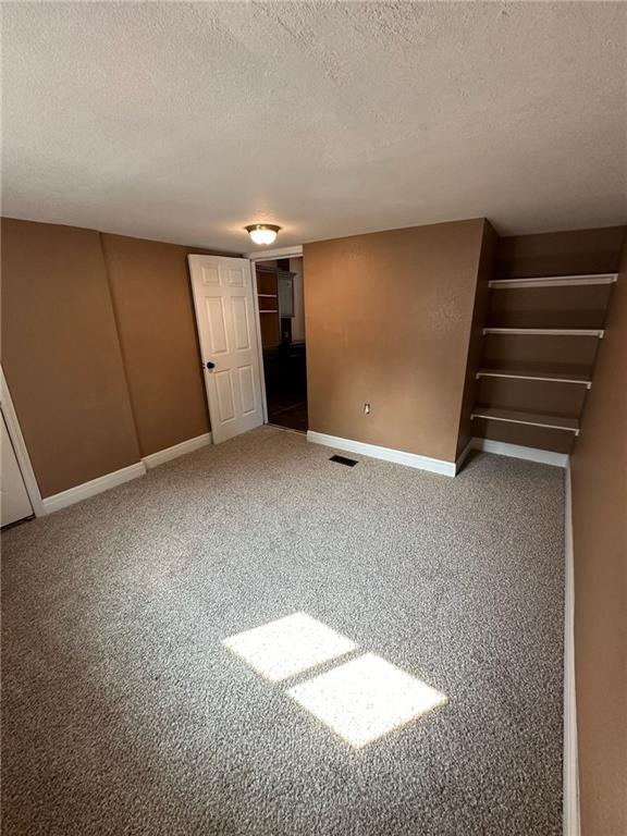 interior space with a textured ceiling and carpet