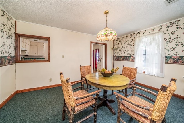 dining area featuring carpet floors, ornamental molding, and a textured ceiling