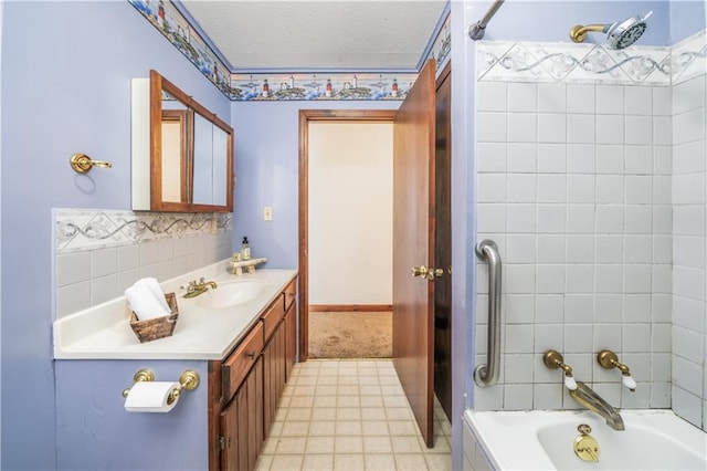 bathroom featuring vanity, tiled shower / bath combo, and a textured ceiling