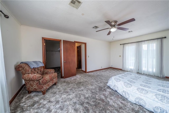 bedroom featuring a walk in closet, carpet, ceiling fan, and a closet