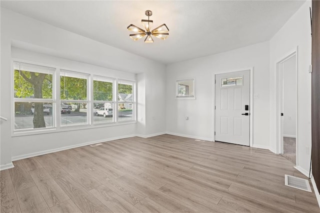 interior space featuring an inviting chandelier and light hardwood / wood-style floors