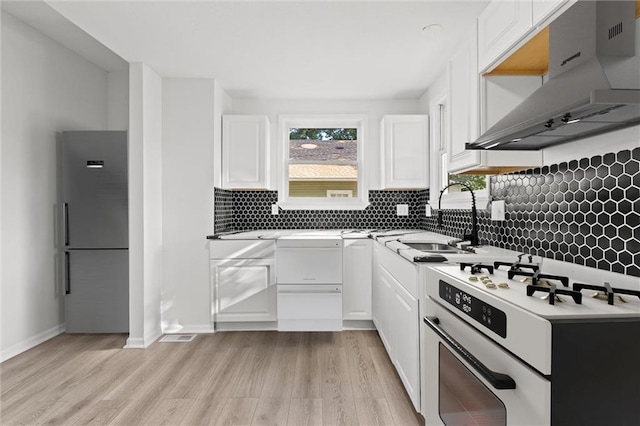 kitchen featuring exhaust hood, stainless steel fridge, light hardwood / wood-style flooring, stove, and white cabinets