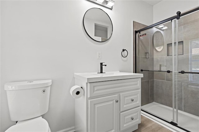 bathroom with walk in shower, toilet, hardwood / wood-style flooring, and vanity