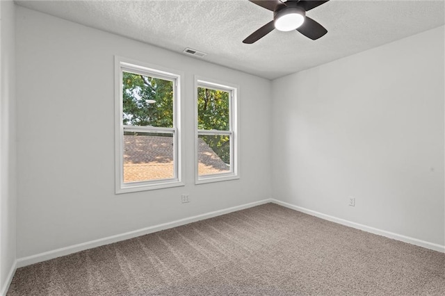 carpeted spare room featuring ceiling fan and a textured ceiling