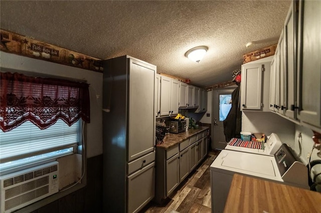 kitchen featuring a textured ceiling, dark hardwood / wood-style flooring, washer and dryer, and gray cabinets