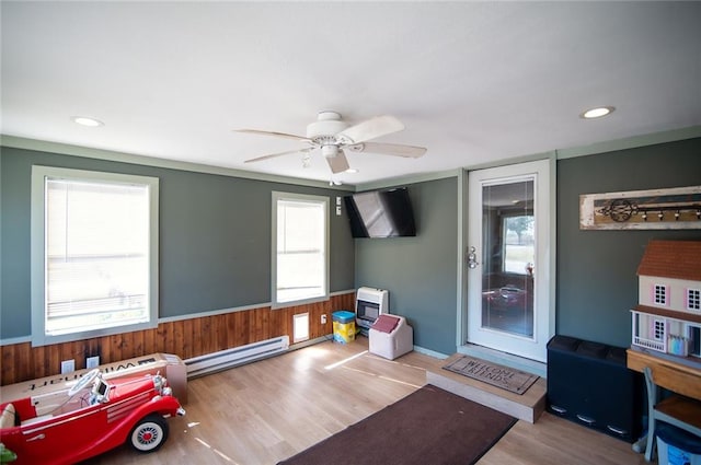 interior space with ceiling fan, light hardwood / wood-style flooring, plenty of natural light, and a baseboard heating unit