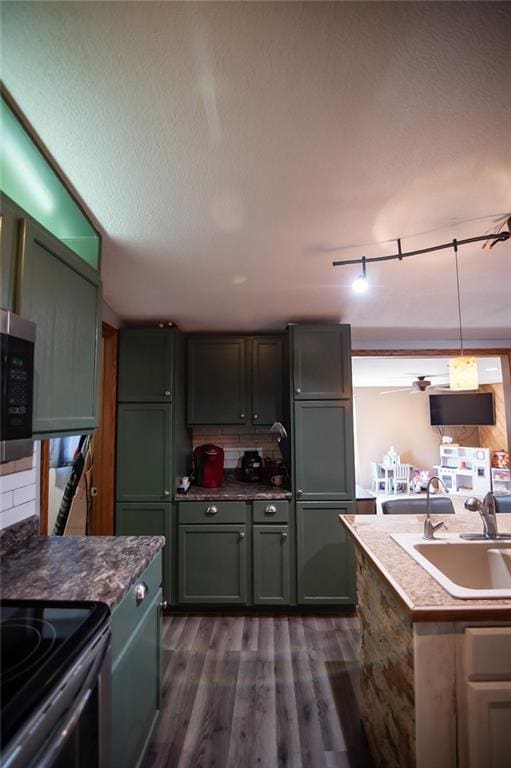 kitchen featuring green cabinetry, dark wood-type flooring, sink, black range with electric stovetop, and backsplash