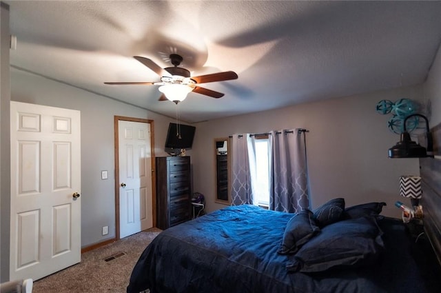 bedroom with ceiling fan, carpet floors, and a textured ceiling