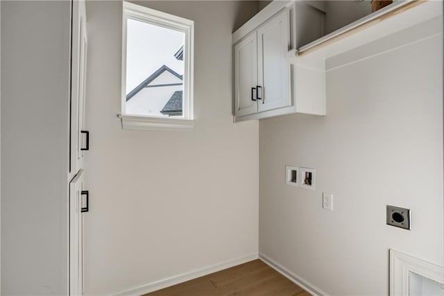 clothes washing area with cabinets, washer hookup, hookup for an electric dryer, and hardwood / wood-style floors