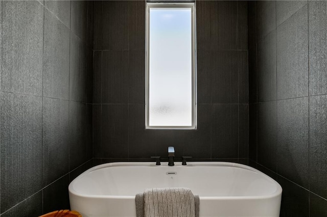 bathroom with tile walls and a bath