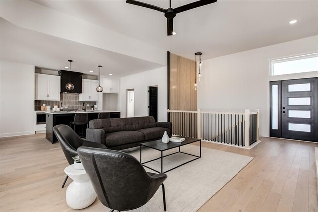 living room featuring ceiling fan and light hardwood / wood-style flooring