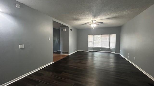 spare room featuring a textured ceiling, dark hardwood / wood-style floors, and ceiling fan