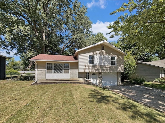 tri-level home featuring brick siding, a garage, a front lawn, and driveway