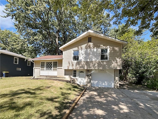 tri-level home featuring a garage, a front lawn, concrete driveway, and brick siding