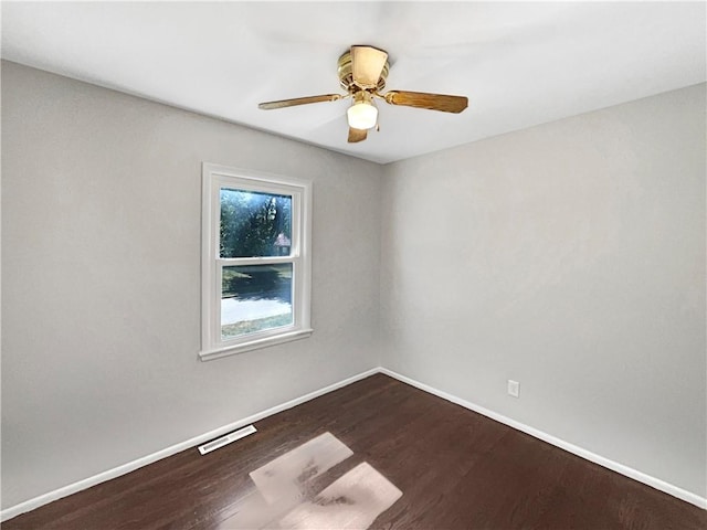 empty room featuring visible vents, ceiling fan, baseboards, and wood finished floors