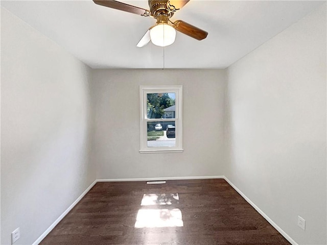 empty room featuring visible vents, a ceiling fan, baseboards, and wood finished floors