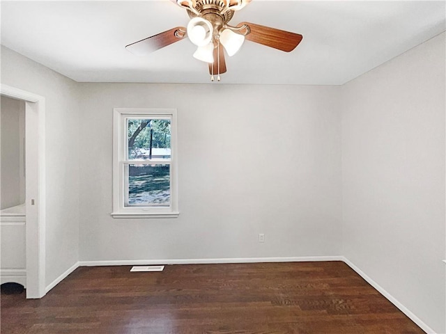 unfurnished room featuring a ceiling fan, wood finished floors, visible vents, and baseboards