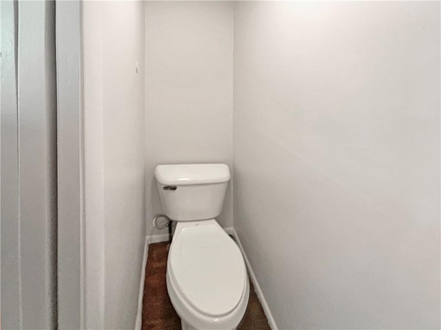 bathroom featuring toilet and baseboards