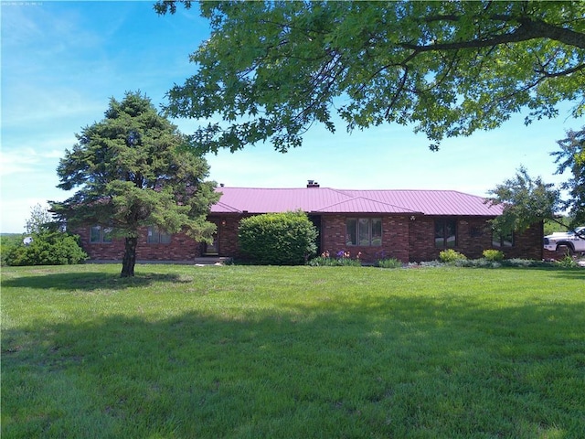 27061 Willow Dr, Paola, KS 66071 - single story home featuring a front lawn, metal roof, and a chimney