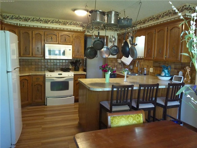 27061 Willow Dr, Paola, KS 66071 - kitchen featuring white appliances, brown cabinets, and a peninsula