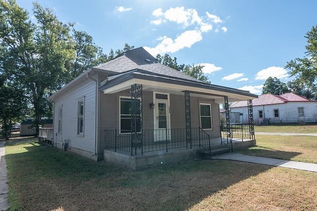 bungalow with covered porch and a front yard