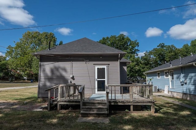 rear view of property with central AC unit, a yard, and a wooden deck