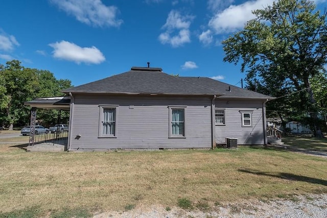 rear view of property with a yard and central AC