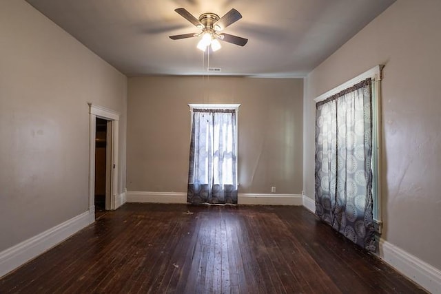 empty room featuring dark wood-type flooring and ceiling fan