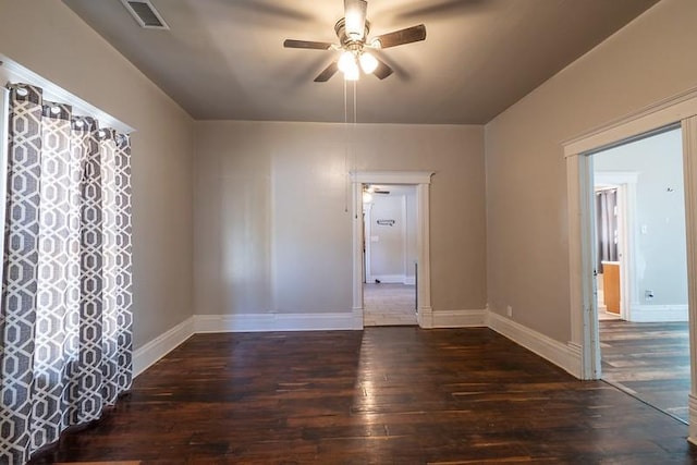 empty room featuring dark wood-type flooring and ceiling fan