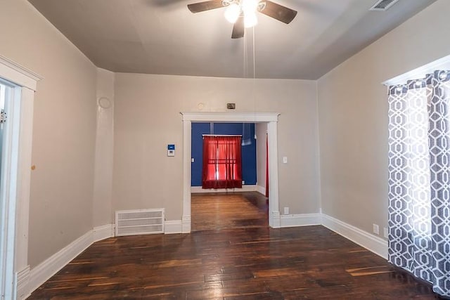 empty room with ceiling fan and dark hardwood / wood-style flooring